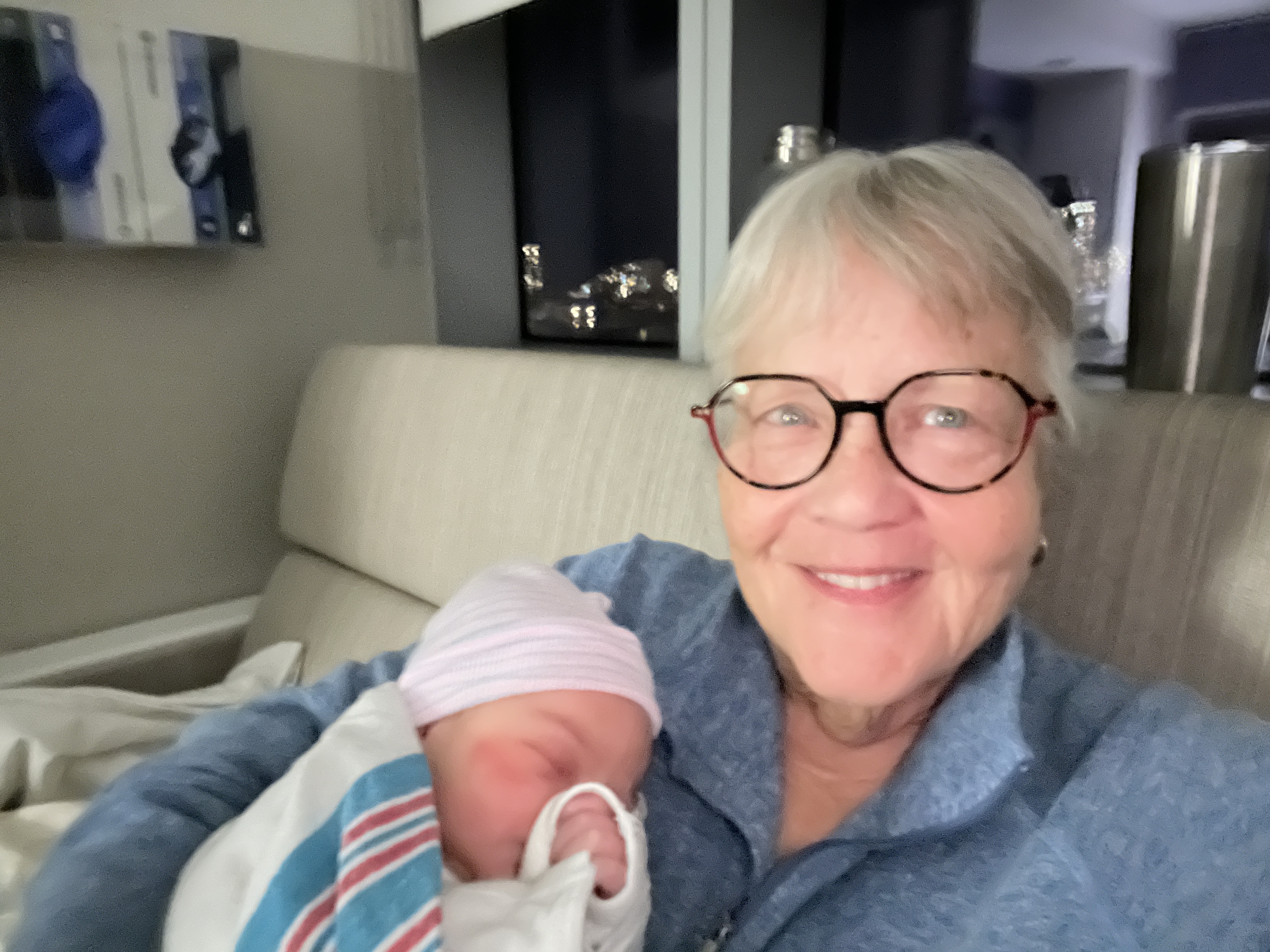 Pat Dodge holding a newborn — 40 years as a birth midwife